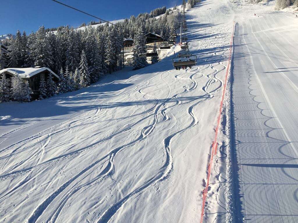 Freestyle skiers enjoying jumps, rails, and snowpark features in the Three Valleys ski area.