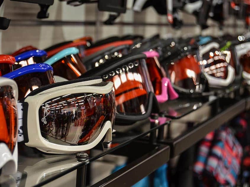 Display of ski goggles and winter sports accessories available for hire in a professional ski rental shop.
