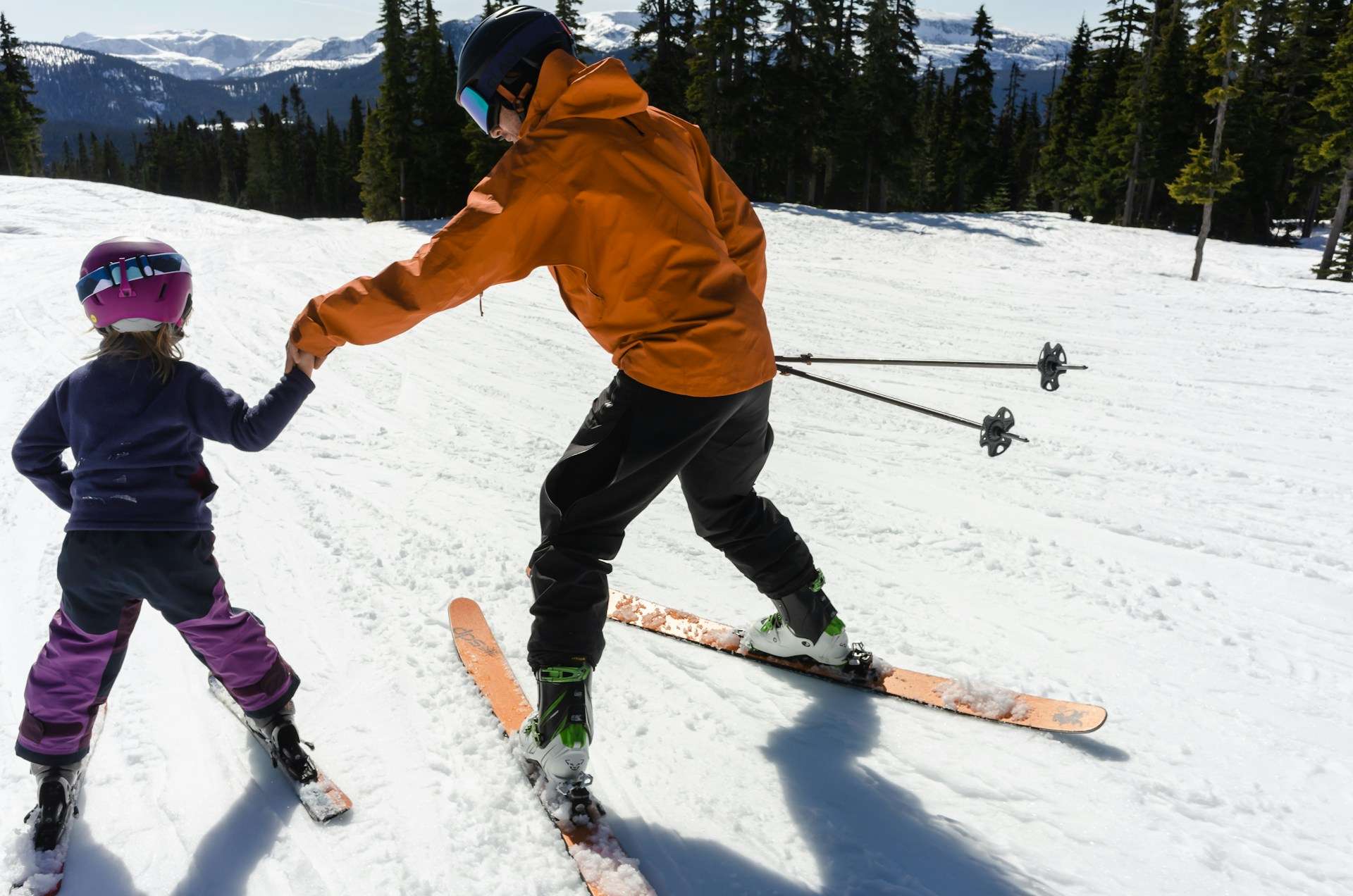 a woman teaching a child how to ski